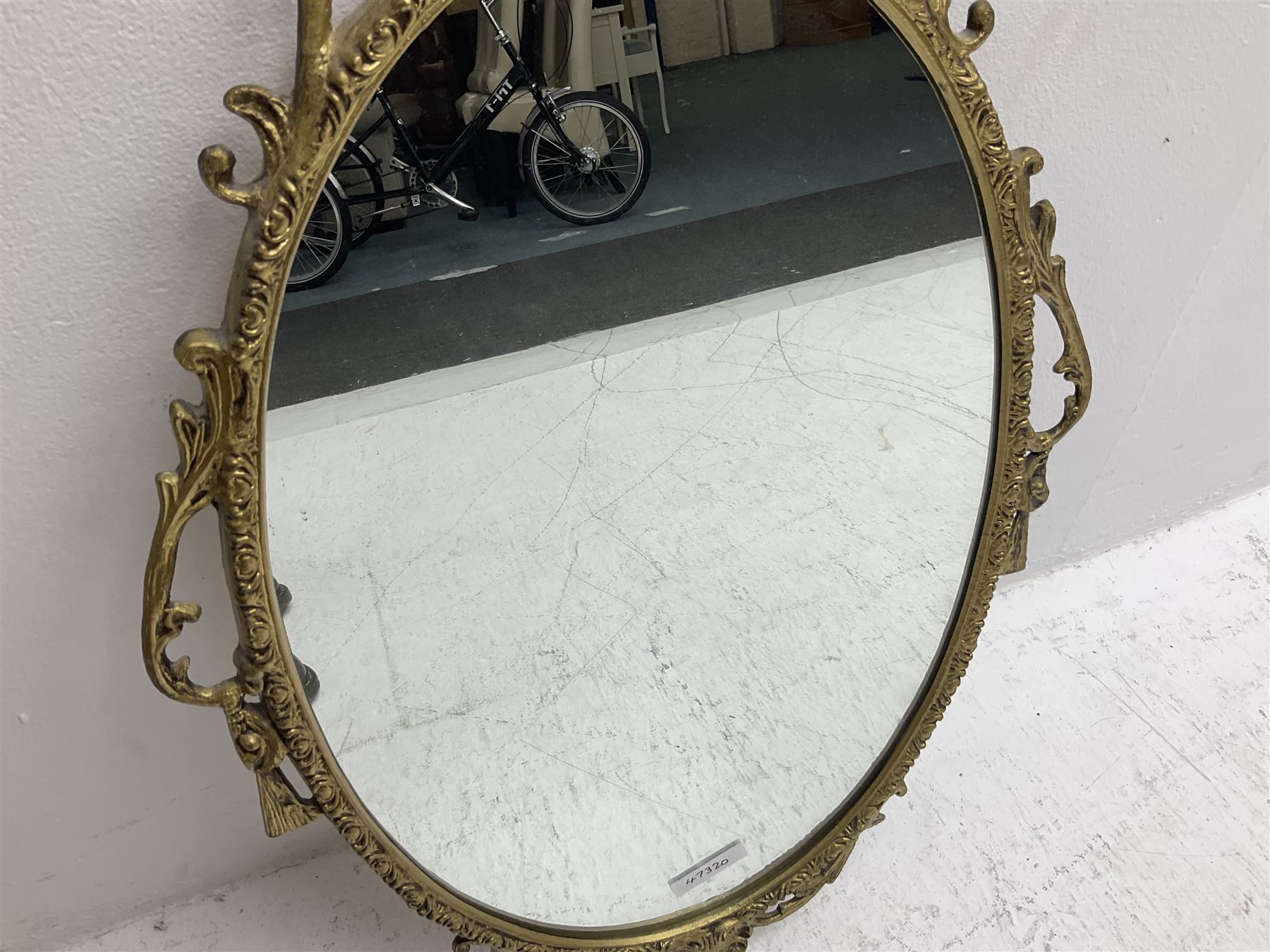 Ornate brass wall mirror with oval plate, L78cm