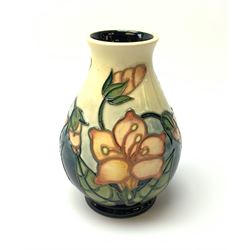 A Moorcroft vase, of bulbous form, c.1999, decorated with pink flowers upon a merging off white and blue glazed ground, with impressed and painted marks beneath, H13.5cm. 