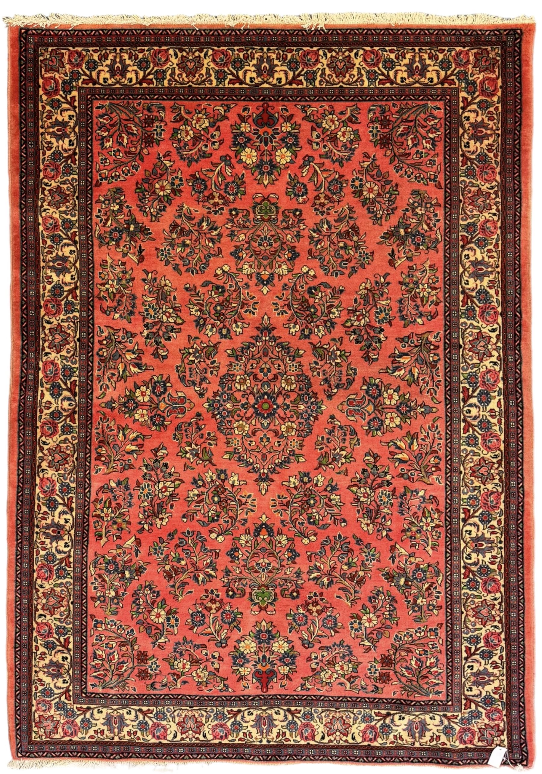 North West Persian Sarouk peach ground rug, the field decorated with floral bunches, pale ground border with repeating flower head motifs within guard stripes 