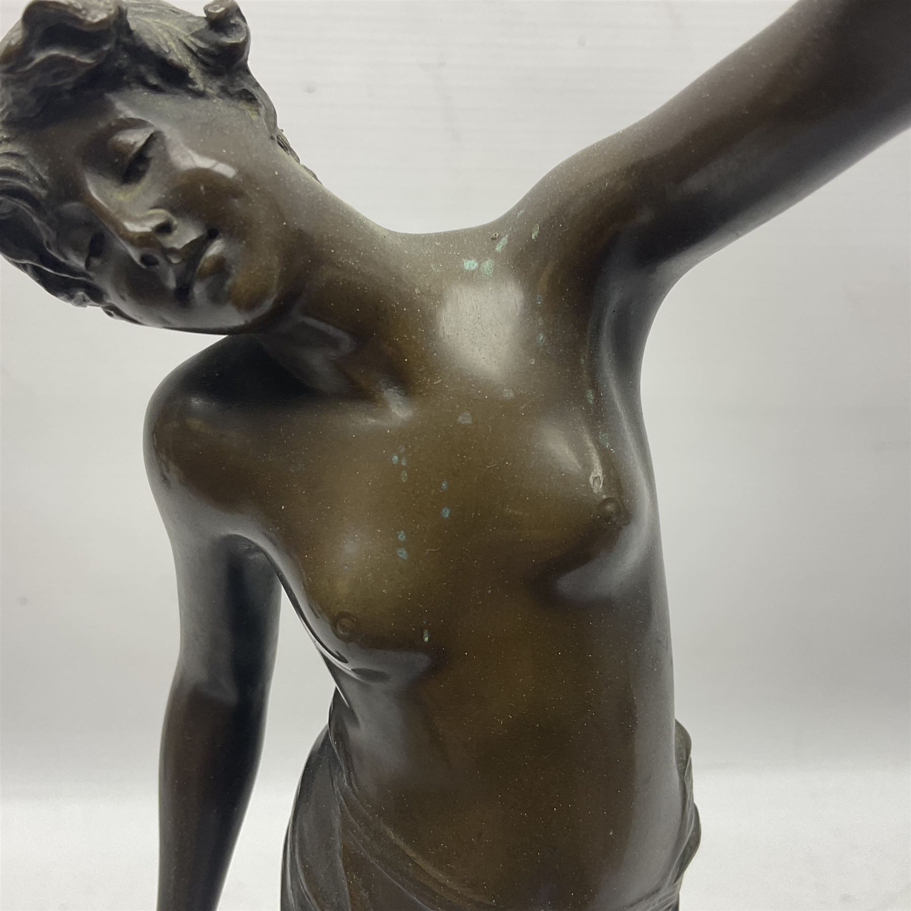 Bronzed semi nude female figure with one hand raised, upon a marble plinth, H43cm  