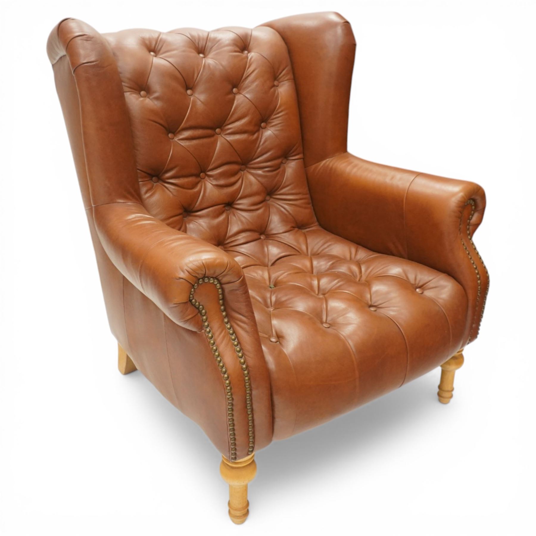 Alexander James design fully tan leather chair, with full button back seat and back, with scrolled arms with studded trim, raised on light stained turned supports