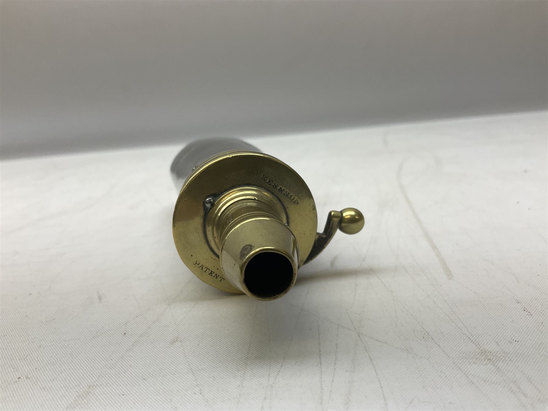 Two Sykes Patent brass mounted small load powder flasks with fire proof safety tops - one with slim plain copper body H17.5cm; the other with plain gun metal body H19cm (2)