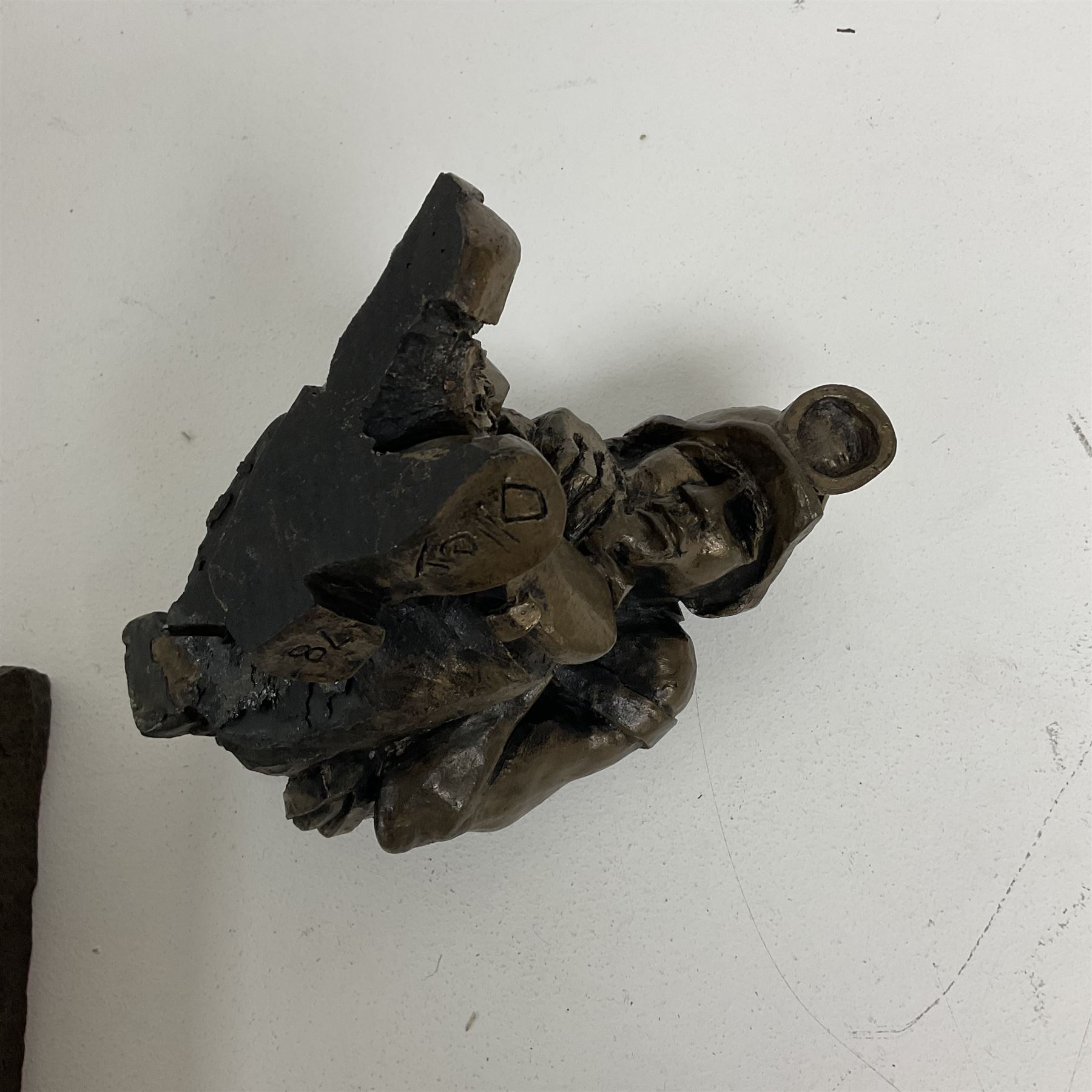 Bronzed cold cast figure of a miner sat beside a lamp by Robert Olley on rocky square plinth base, H17cm