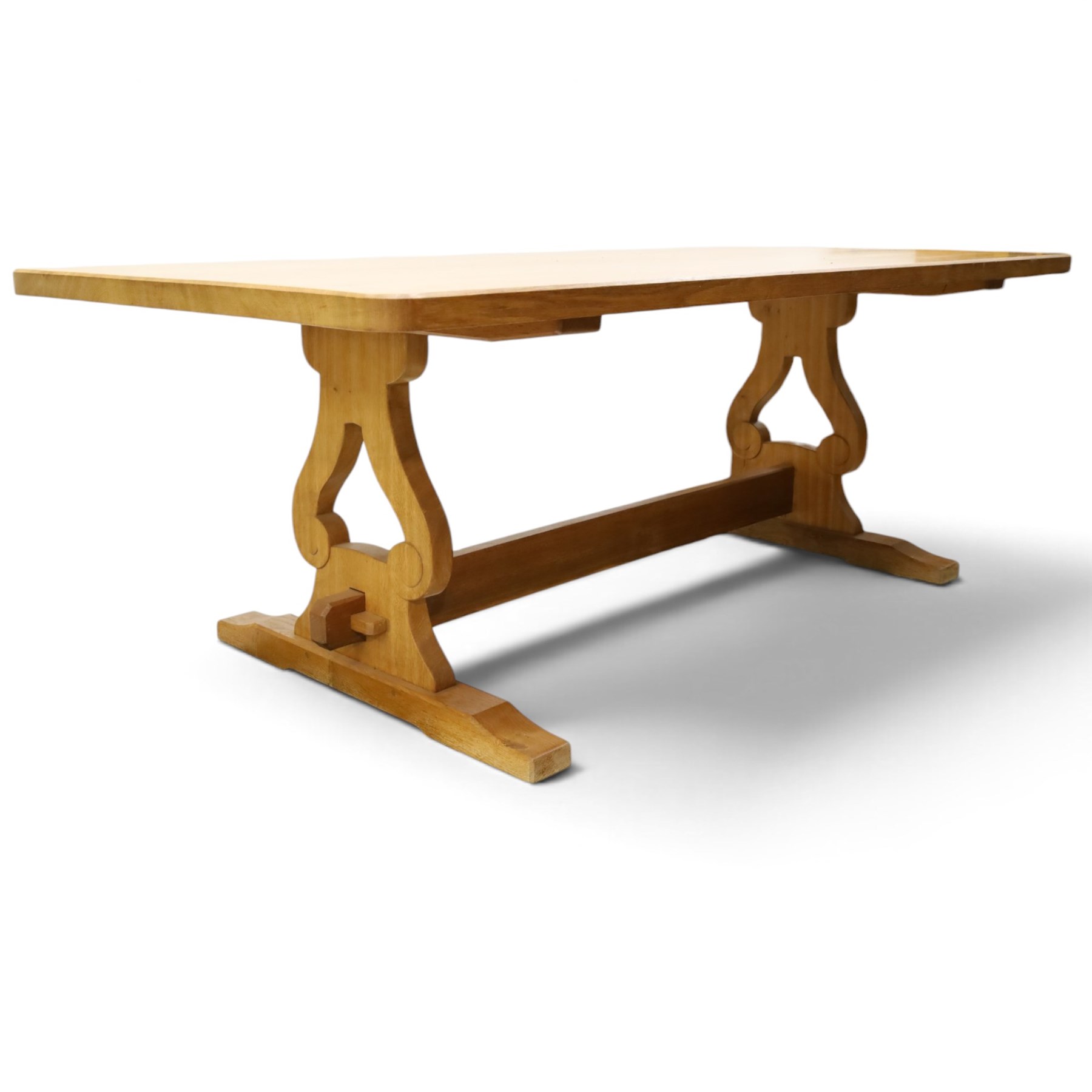 Acorn Industries - oak dining table, rectangular top with rounded corners and chamfered edge, raised on twin lyre-shaped supports united by pegged stretched on sledge feet, carved with acorn signature to stretcher, by Alan Grainger, Brandsby