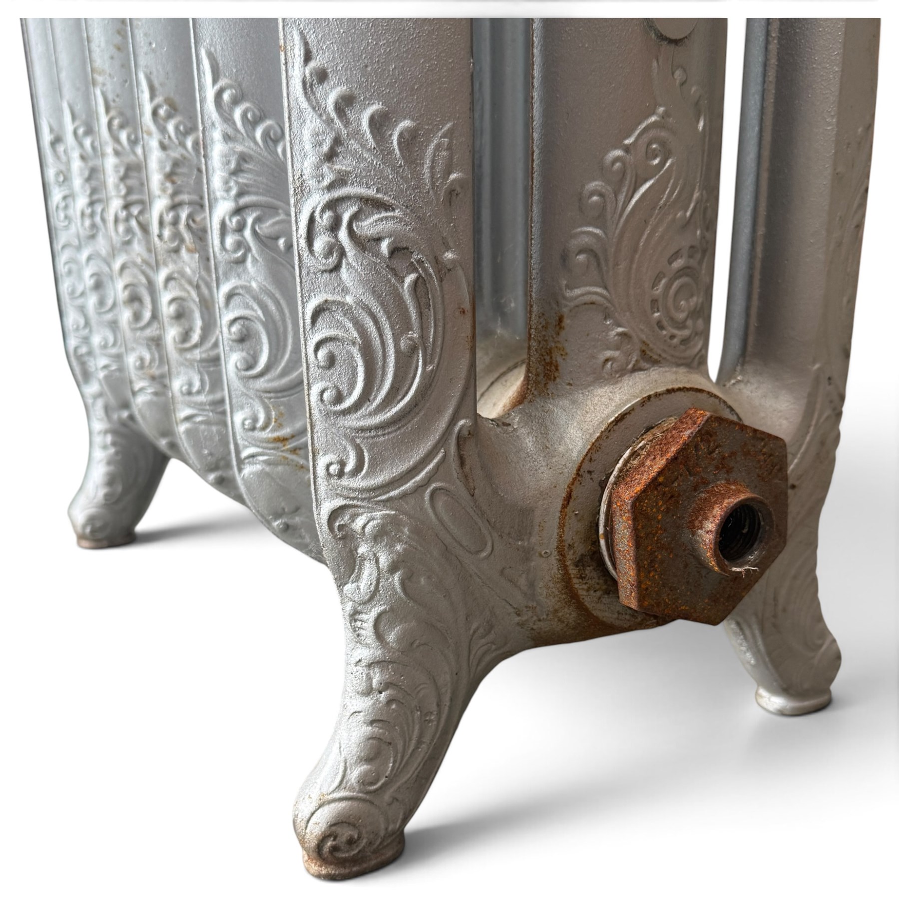 French ornate cast iron column radiator of Rococo Revival design, each section cast with scrolling foliate decoration with rocaille and cartouche motifs, with brass valve and integral bracket feet, in painted silvered finish