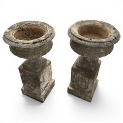 Pair of 20th century cast stone urns on plinths 