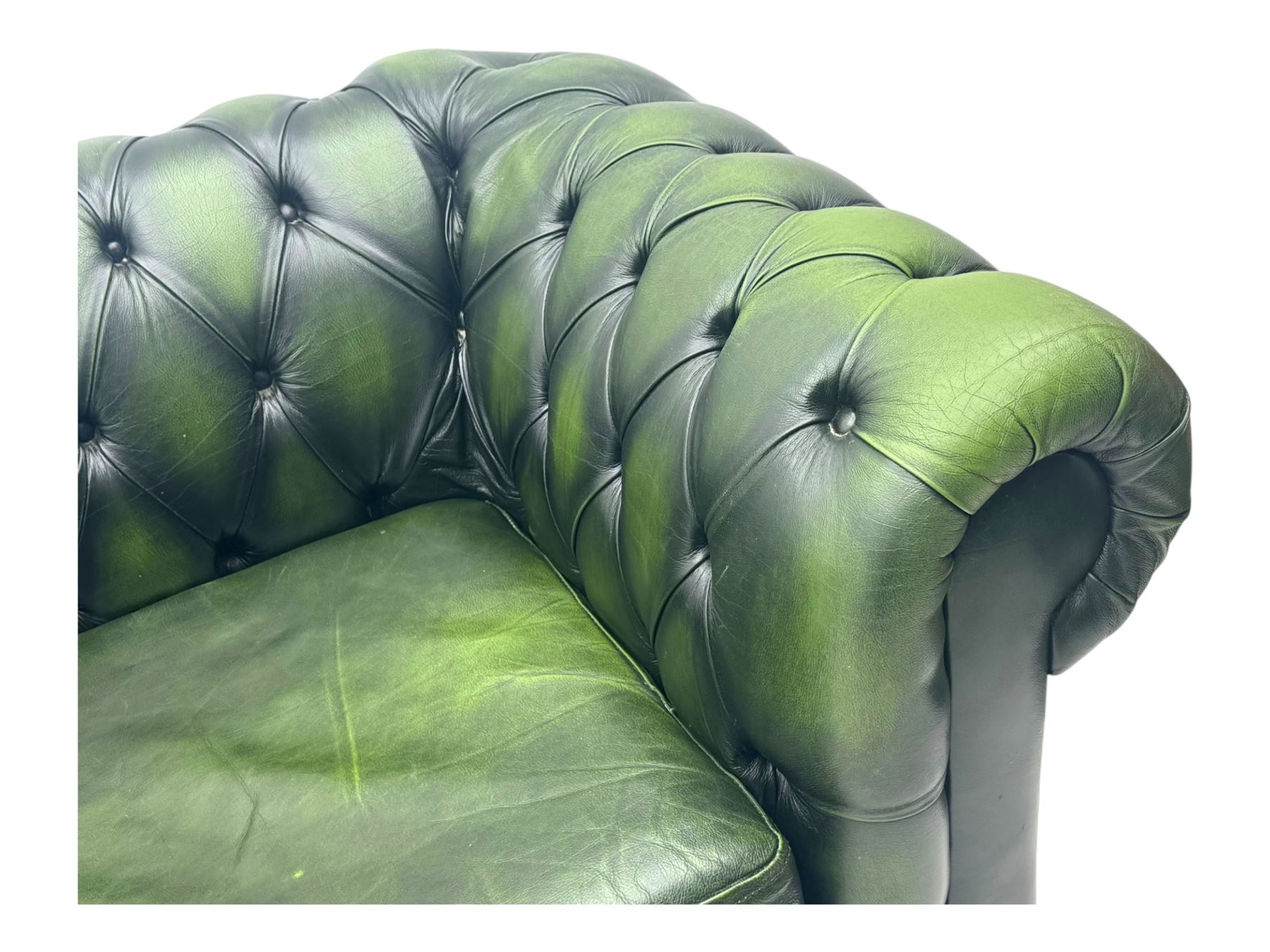 Two seat Chesterfield design sofa bed, upholstered in emerald green leather with deep-buttoned detailing, rolled arms, two loose seat cushions, and pull-out 