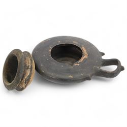 Etruscan terracotta oil lamp, with black glaze, flat loop handle and laurel leaf border, the opening with later turned wooden collar, signed to base 'repaired by one James Naysmith 1887', H7cm 