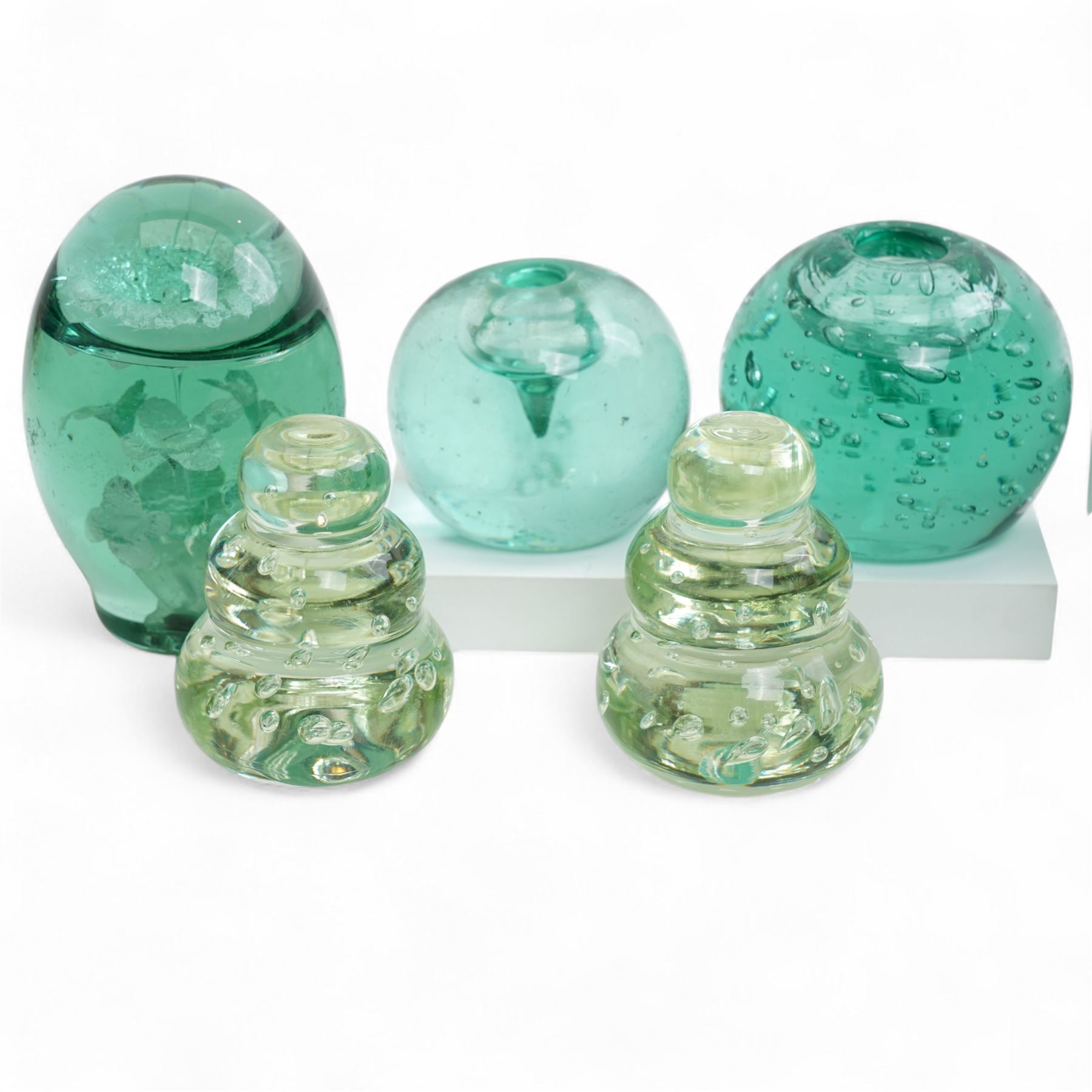 Eleven Victorian and later green glass dump paperweights, with floral and bubble inclusions, largest H14cm 
