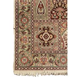 Persian design rug, overall green ground, decorated with panels depicting garden scenes, floral design border with trailing leafy branch, within guard stripes