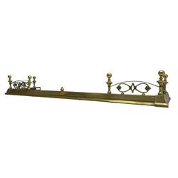 Early 20th century brass telescopic fire fender, turned finials and arched rails enclosing scrolling mounts with foliate decoration 