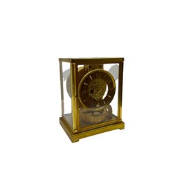 A 1950’s  gilt brass cased Jager- LeCoultre Atmos Clock, 15 jewelled Swiss movement inscribed LeCoultre Atmos with the serial number 71619 , five glazed panels, chapter ring with applied Arabic and baton hours with matching hands, skeletonised movement with oscillating balance wheel beneath, three leveling feet to the base and pendulum lock, with original booklet.
Created by the Jaeger LeCoultre watchmakers in 1928 the Atmos clock receives its power from minute changes in atmospheric temperature, hence the clocks name.  Within a sealed capsule, a mixture of gases expand and contract with each temperature change. At a temperature between 15° and 30° Celsius, a variation of a single degree is enough to power the clock for two days. In order to operate, the clock functions with an almost complete lack of friction. 
