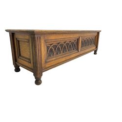 Early 20th century oak ‘bay window’ shaped blanket chest or coffer, hinged top, the front with two lunette carved panels flanked by fluted uprights, on turned feet