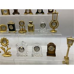 Collection of miniature clocks, predominantly with quartz movements, to include example modelled as an armchair, Edinburgh crystal glass example, clock modelled as a flower, sewing machine etc