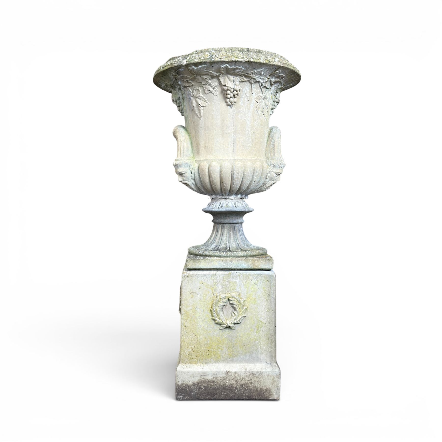 Cast stone classic garden urn, the rim decorated with leaves and berries, twin handles with face masks, raised on square base, stamped HGC