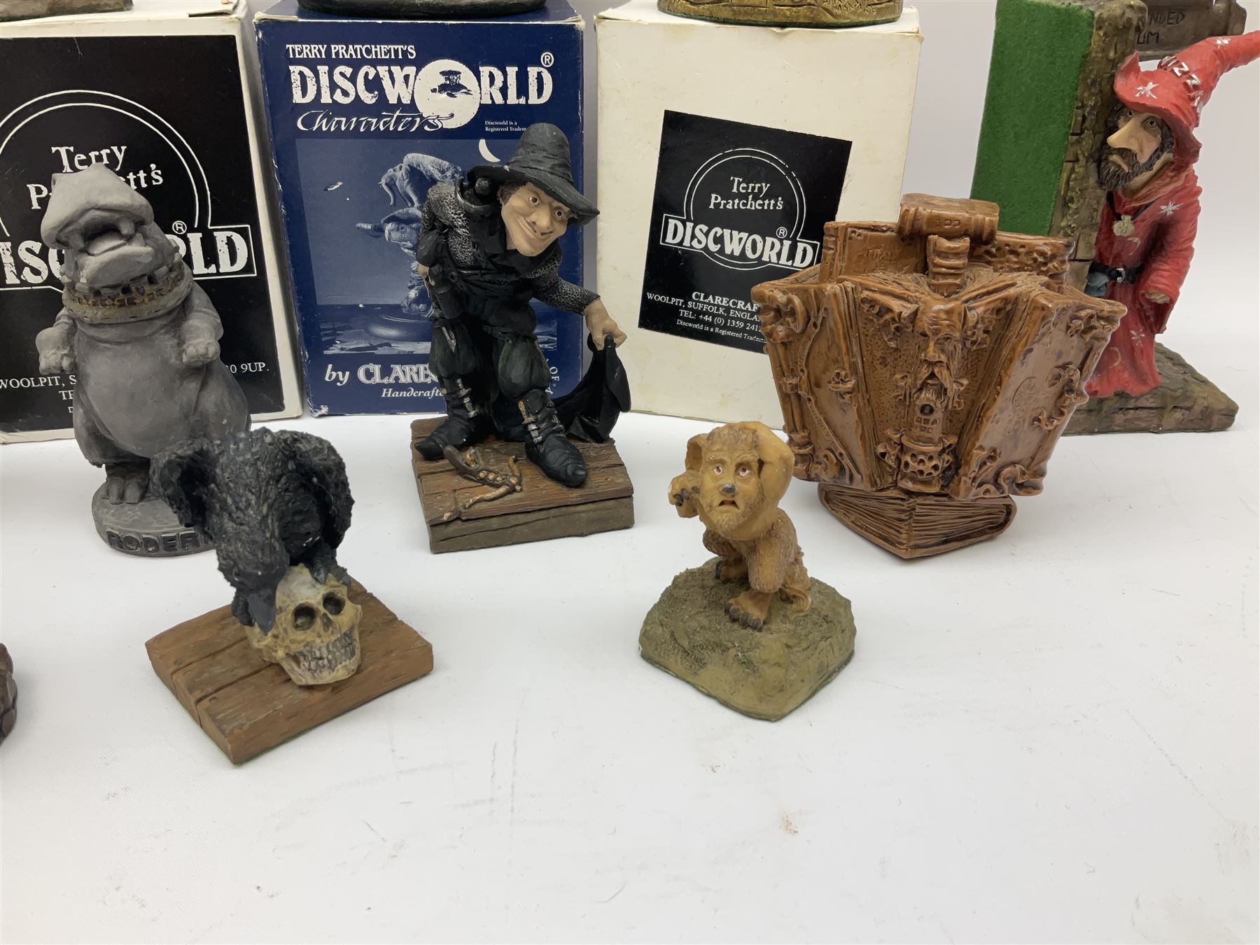 Terry Pratchett Discworld figures, comprising Roderick the hippo, DWE2, a 1995 event piece, Rincewind bookend, DW11, Death bookend, DW12, Librarians wizard knob, boxed, DW55, the luggage, boxed, DW04, tankard from the mended drum, DW21, Teppic the assassin, DW32, Greebo, DW45, Herne the hunted, DW64, Gaspode,  DW31, Quoth on skull, DW49 and Dibbler's compass DW16. 
