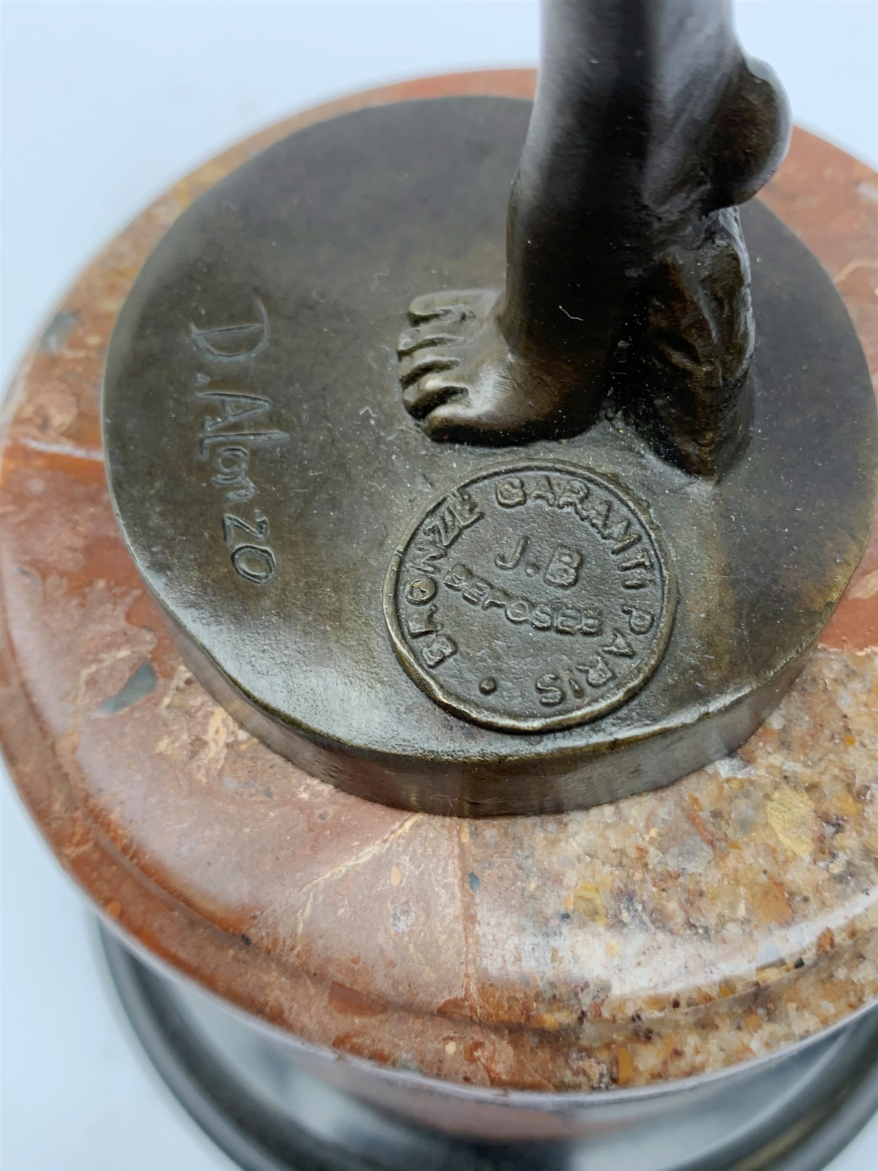 An Art Deco style bronze after D Alonzo, modelled as a female hoop dancer, with impressed mark and foundry mark, raised upon a cylindrical marble base, overall H47cm. 