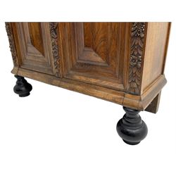 Late 17th century Flemish/Dutch rosewood and oak ‘Zeeuwse Kast’ or cupboard, projecting cornice carved with three putti masks, the uprights carved with lion masks over ribbons, flower heads and foliage, enclosed by four geometric panelled doors, lower central upright carved with flower head over foliate ribbon with bird among foliage, the escutcheon hidden by swivel berry carved cover, interior fitted with shelves, two drawers and shallow hinged cupboard, on two large turned and ebonised feet, circa 1680