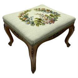 19th century French walnut dressing stool, rectangular seat upholstered in a floral needlework tapestry top, shaped apron with applied carved flower heads, on cabriole supports with acanthus carved feet