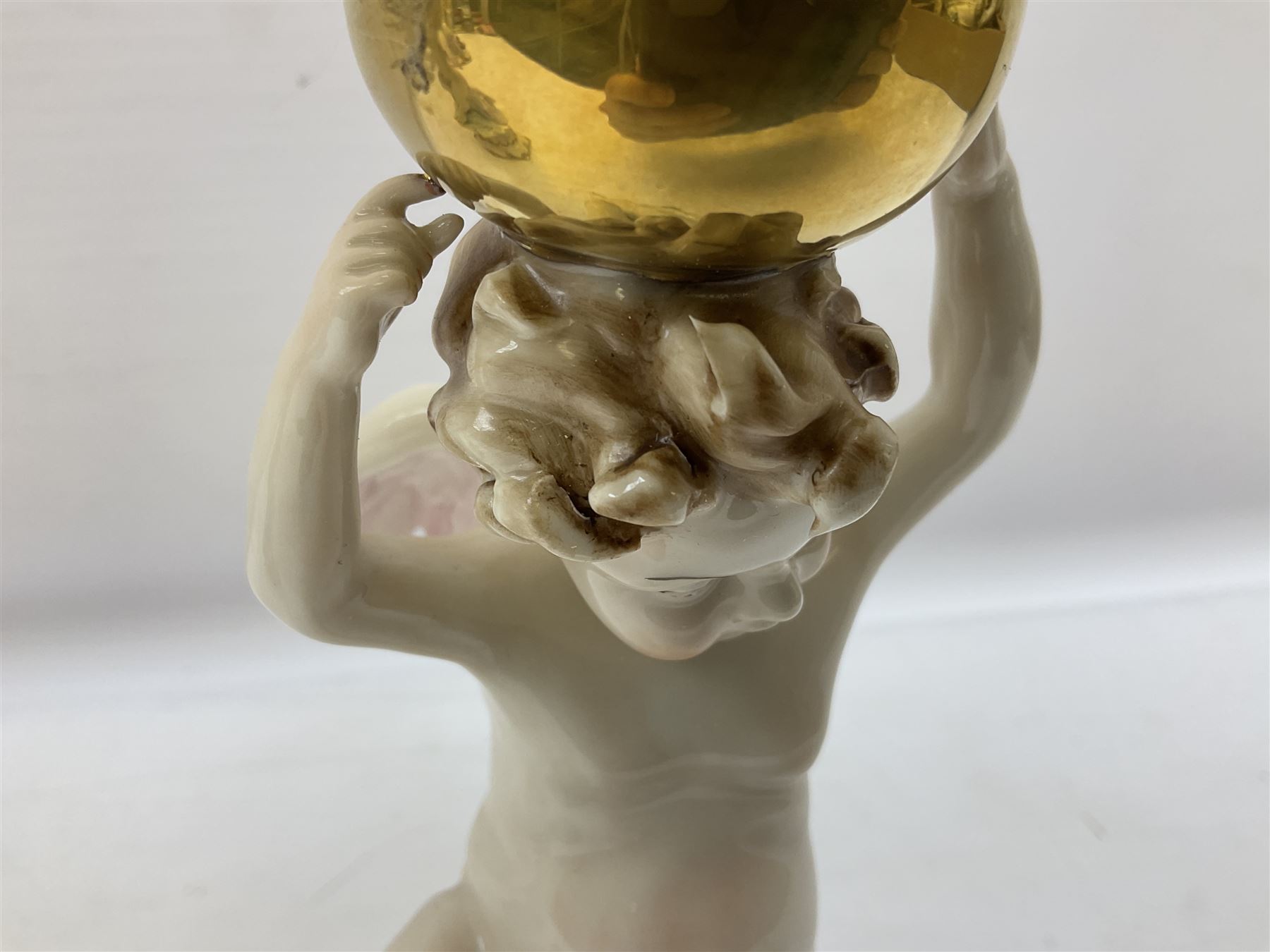 Pair of Capodimonte table lamps, in the form of cherubs holding a brass fitting, together with a pair of large Capodimonte figures in the form or a man and woman resting up on tree stump, largest example H57cm