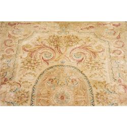 Large Aubusson design flatweave carpet, cream ground centred by oval medallion decorated with scrolling acanthus leaves and flowerheads, surrounded by floral sprays, foliate scrolls and rocaille motifs in muted pink, blue and gold tones, enclosed by conforming foliate border
