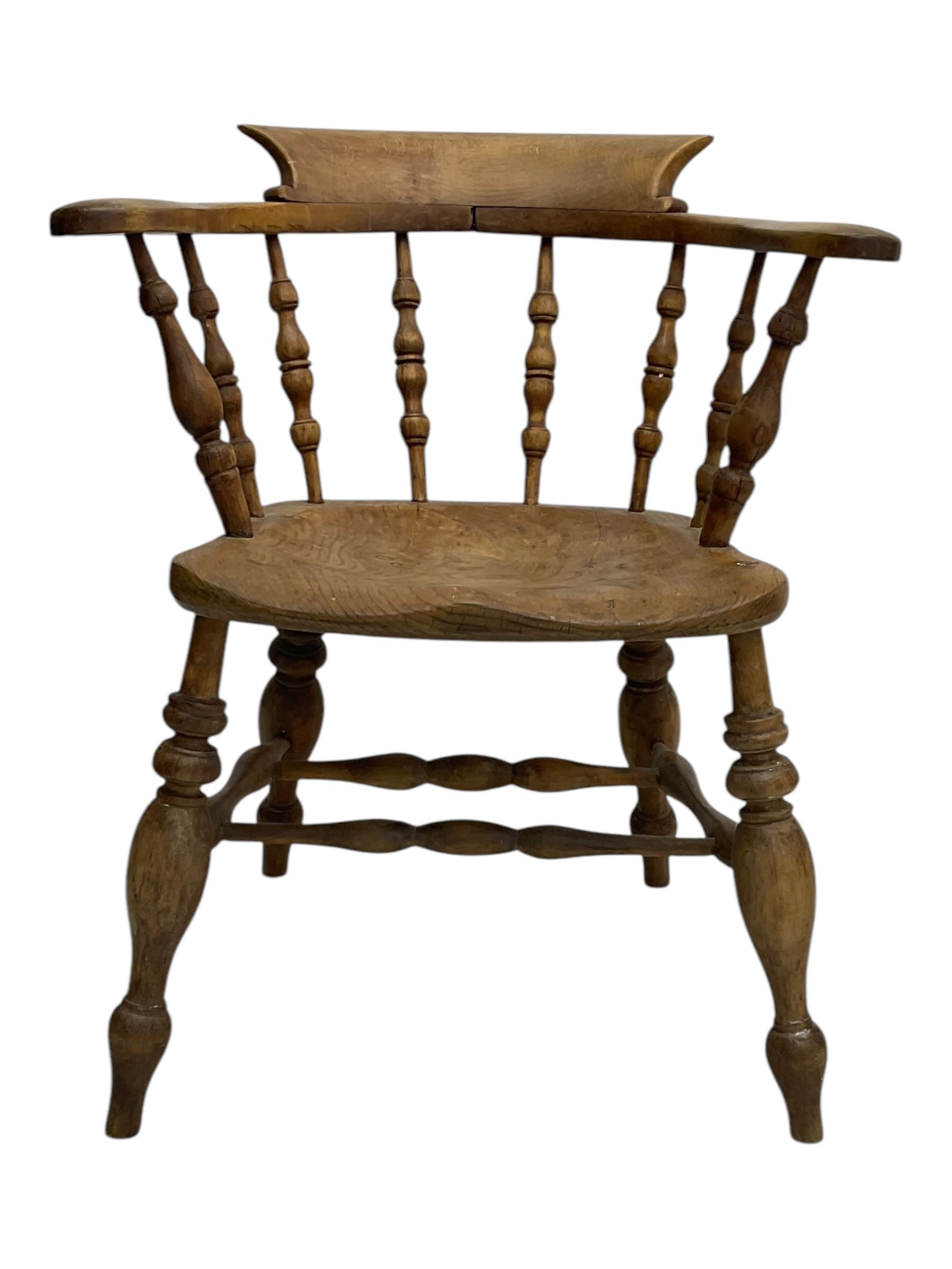Late 19th century elm smoker’s bow armchair, curved top rails over turned spindle backs, shaped seats, raised on turned legs united by turned stretchers; together with a similar smoker’s bow armchair (2)