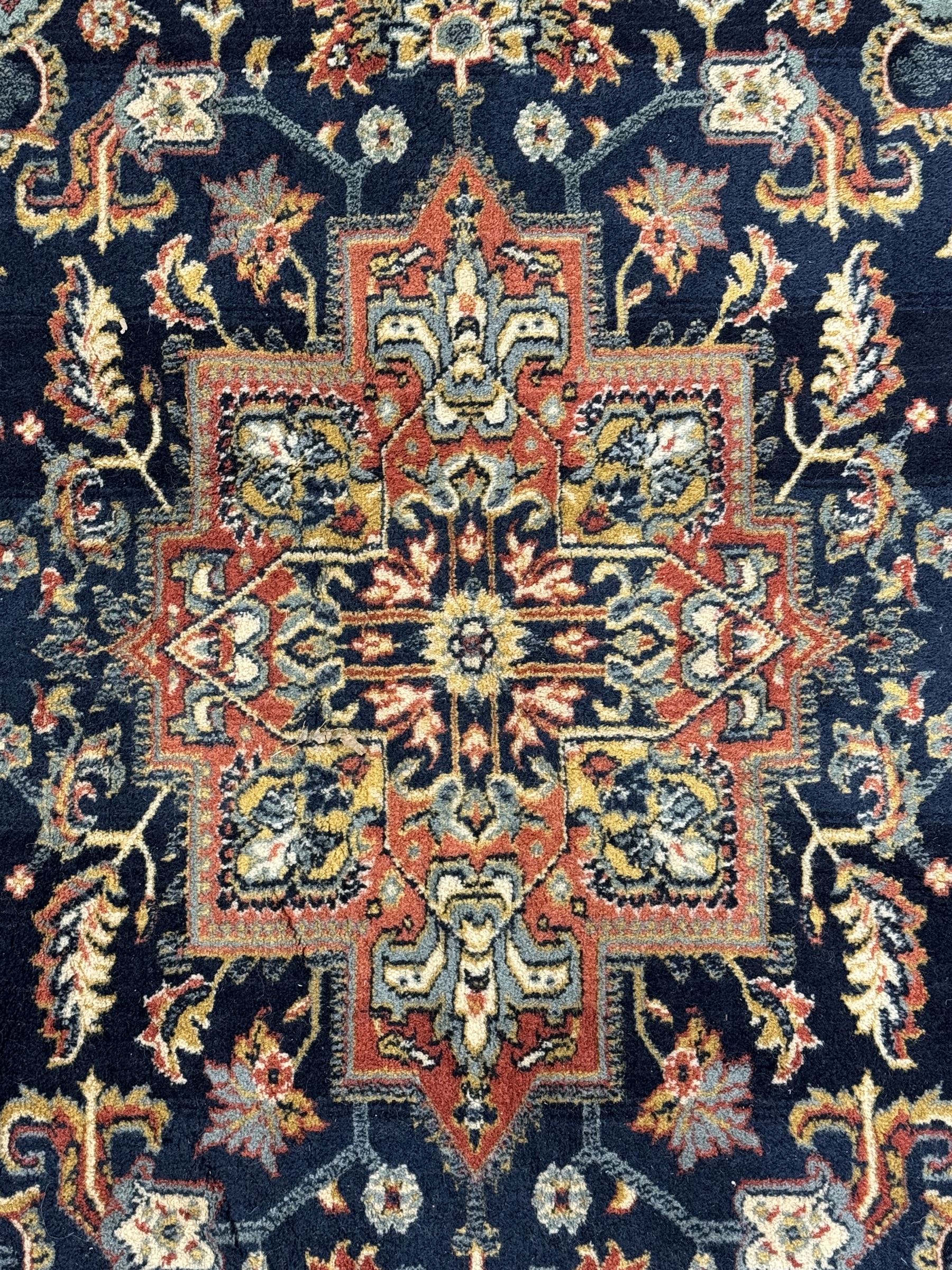 Belgian Sultan woollen ground rug, central navy field densely decorated with floral sprays and geometric patterns (192cm x 135cm); handwoven tribal terracotta ground rug (121cm x 71cm); Persian crimson ground runner, all over stylised floral and foliate motifs (266cm x 94cm)