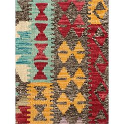 Anatolian Kilim cream ground rug, decorated with repeating diamond motifs in red, blue, yellow, and green, bordered by narrow bands of stylised geometric patterns in contrasting shades