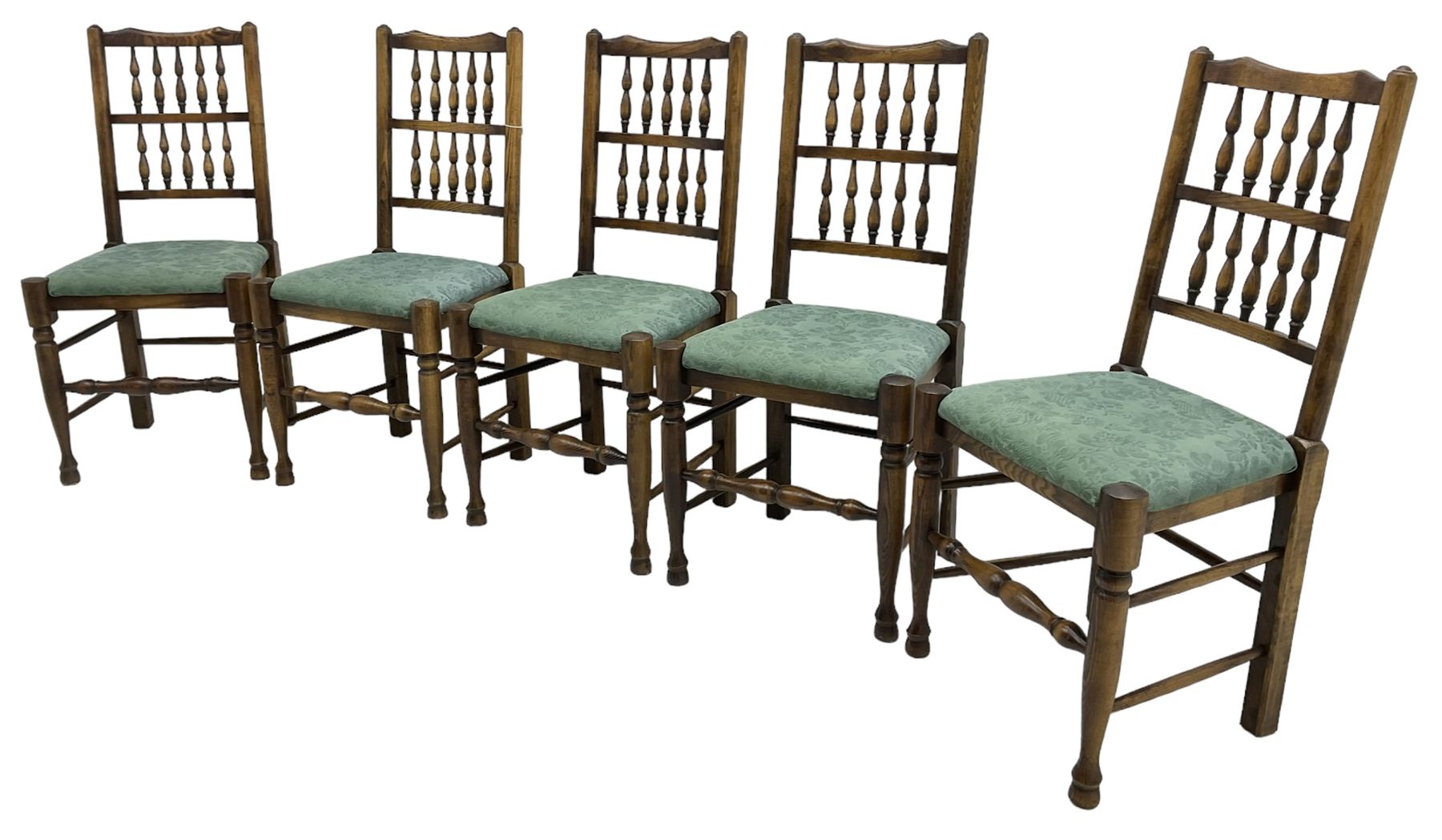 Set of five Lancashire design elm spindle back chairs, shaped cresting rail over two rows of five spindles, upholstered drop-on seats, on turned front supports united by turned stretchers  