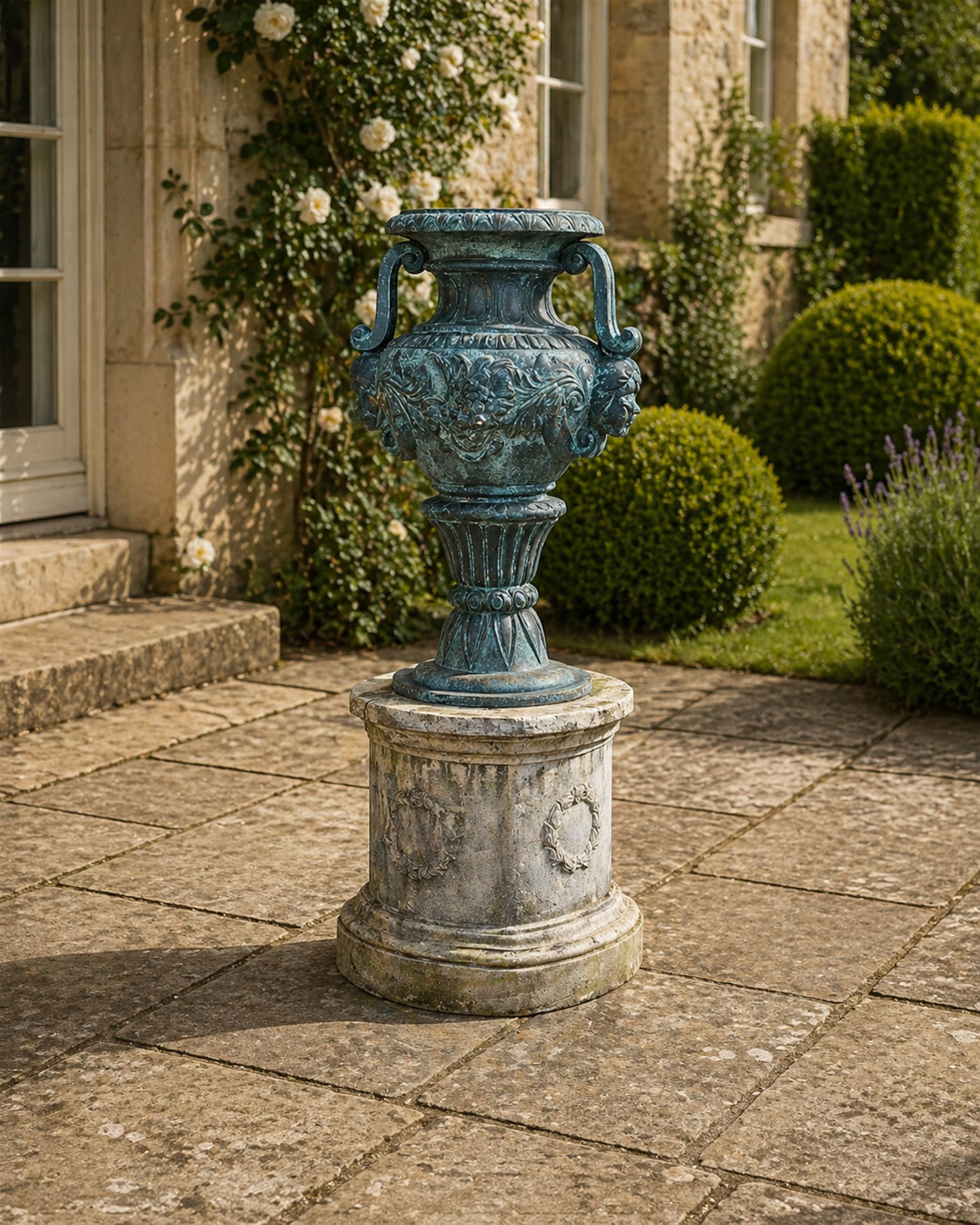 Large impressive Classical cast bronze center-piece urn, twin scroll handles with grape garlands, cherub masks and relief detail, raised on a circular cast stone pedestal with moulded detail