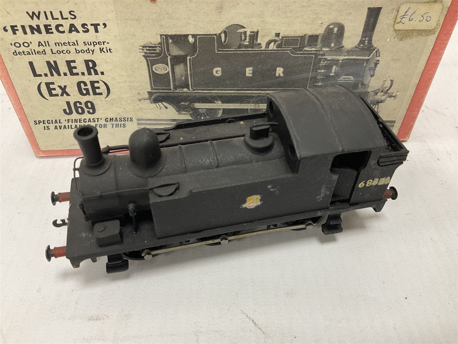 ‘00’ gauge - three steam locomotives and comprising two kit built examples; J69 Class 0-6-0T no.68619 in BR dark blue; J69 Class 0-6-0T no.68626 in BR black; with Wills Finecast boxes; one further similar example Class J67 ‘Buckjumper’ 0-6-0 no.372 being comprised of a singular heavy metal body and chassis; all models with Wills Finecast boxes (3) 