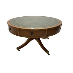 Georgian style yew wood drum table, circular top with green and tooled leather inset, fitted with four drawers, on turned pedestal base with four splayed supports, brass cups and castors