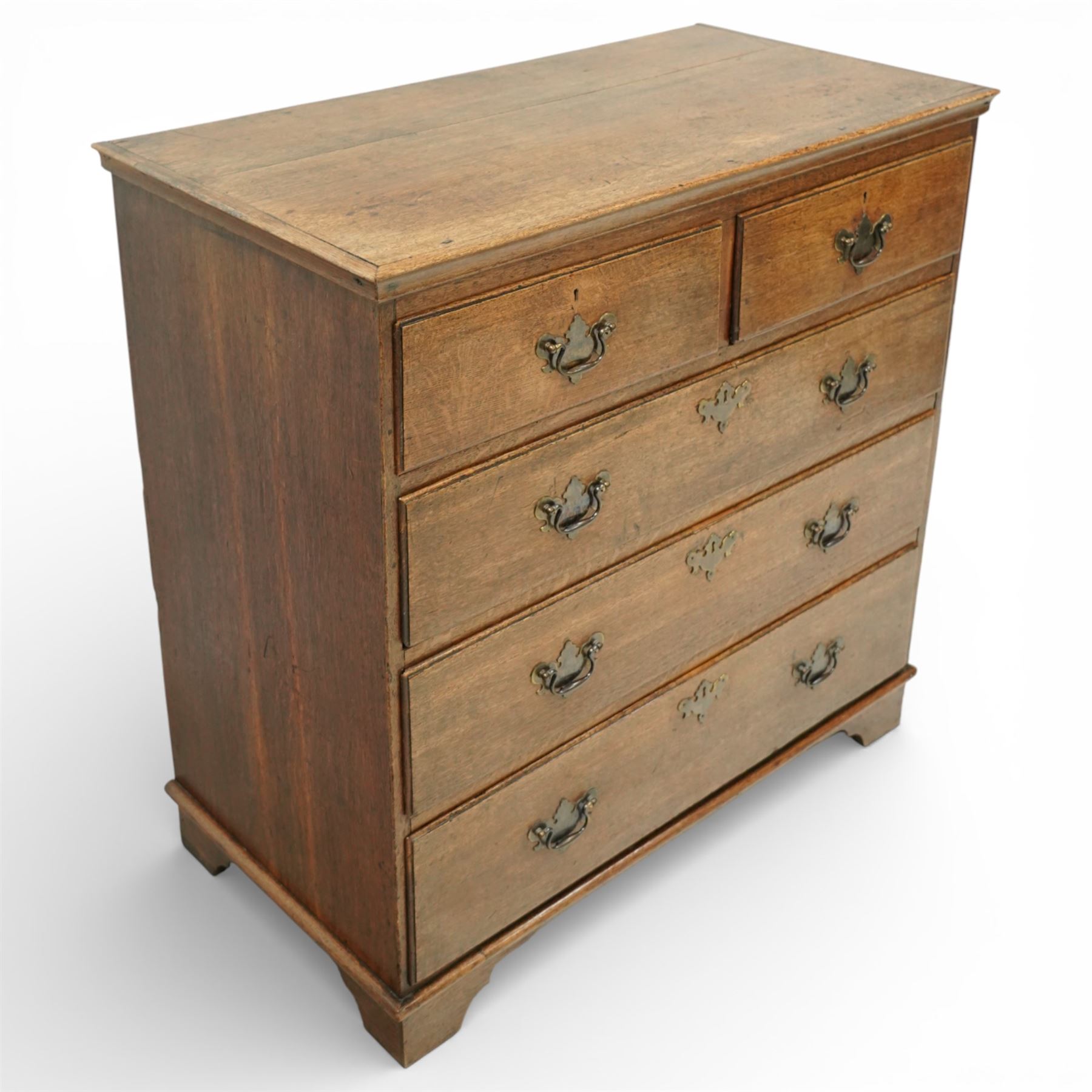 George III oak chest of drawers, the plain moulded top above a two over three drawer arrangement with pierced brass fittings, the case raised on bracket feet