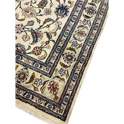 Persian Meshed ivory ground carpet, the field decorated with scrolled interlacing branch and plant motifs, repeating floral design border with guards 