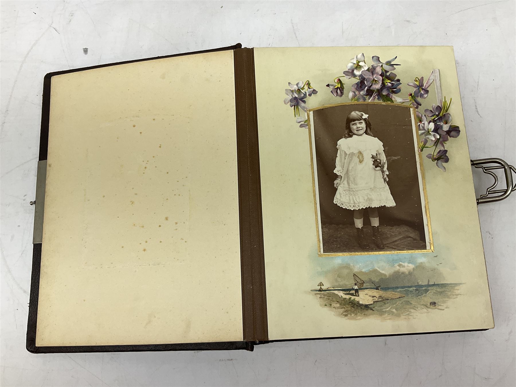 Victorian leather bound photo album, the interior leaves containing apertures of various sizes and shapes of portraits surrounded by printed floral designs, H28cm
