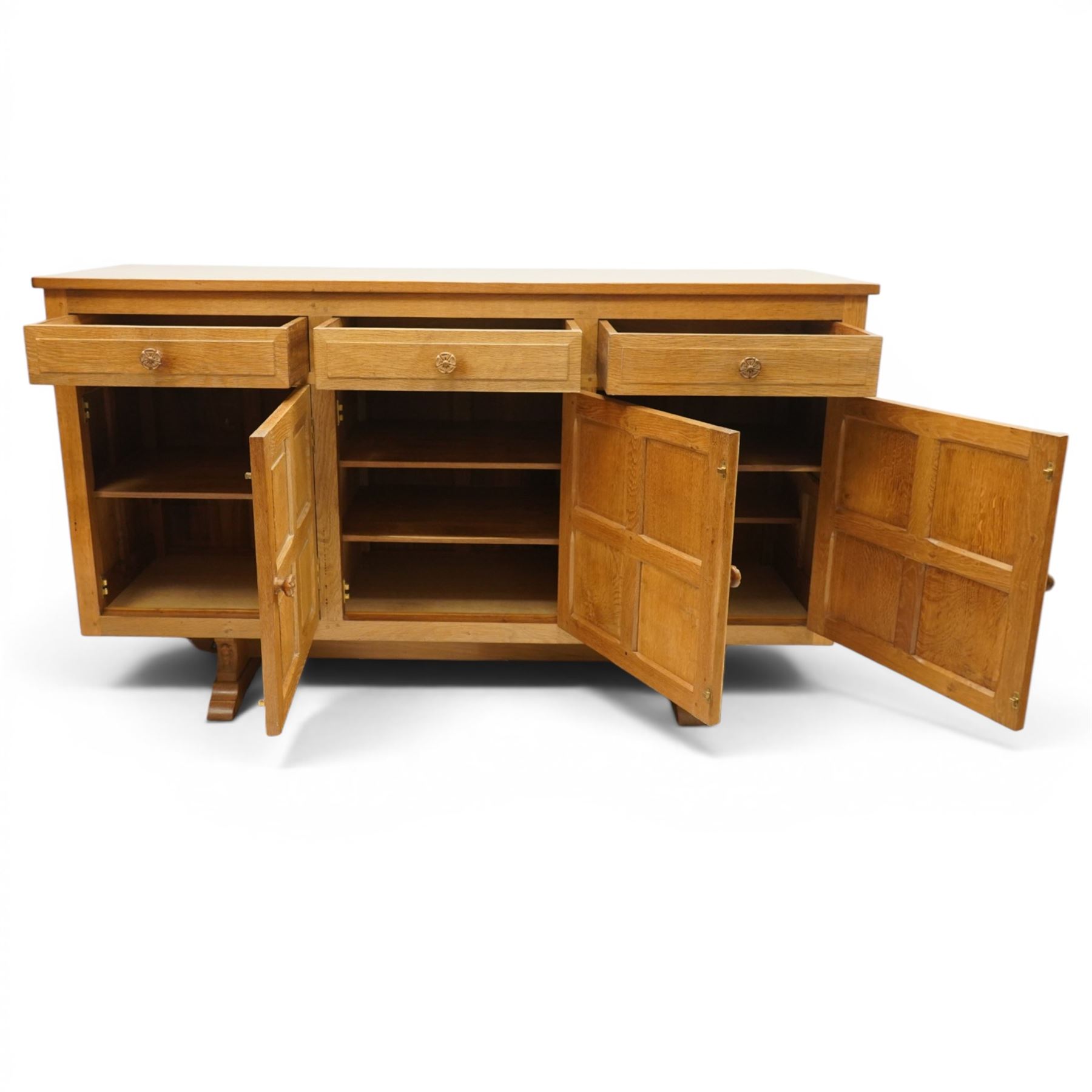 Beaverman - 1980s adzed oak sideboard raised on a trestle base, three drawers over three cupboards with Yorkshire Rose carved handles, fielded panelled sides and front, with carved Beaver, by Colin Almack of Sutton near Thirsk