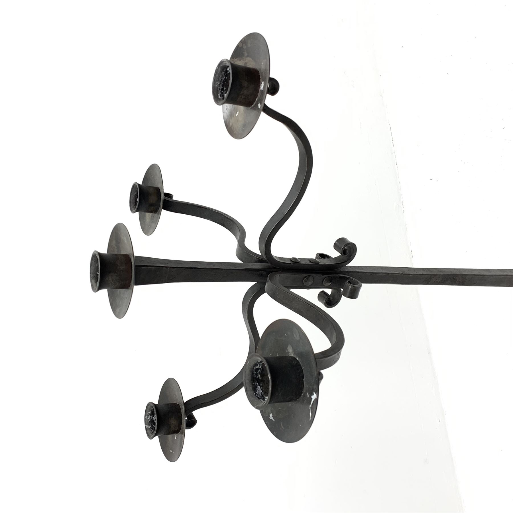 Wrought hand forged iron candle stand, four scrolled branches and central vertical branch with sconces, tapered column on four shaped and out splayed supports