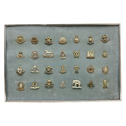 Twenty-eight cap badges for Hussars, Lancers, Dragoon Guards etc including 5th, 9th, 12th, 16th, 17th and 21st Lancers, Kings Own Hussars, 19th P.W.O. Hussars, 8th Kings Royal Irish Hussars, 4th Queens Own Hussars, Kings Dragoon Guards, 4th Royal Irish Dragoon Guards etc; mounted for display in a metal frame 41.5 x 62cm