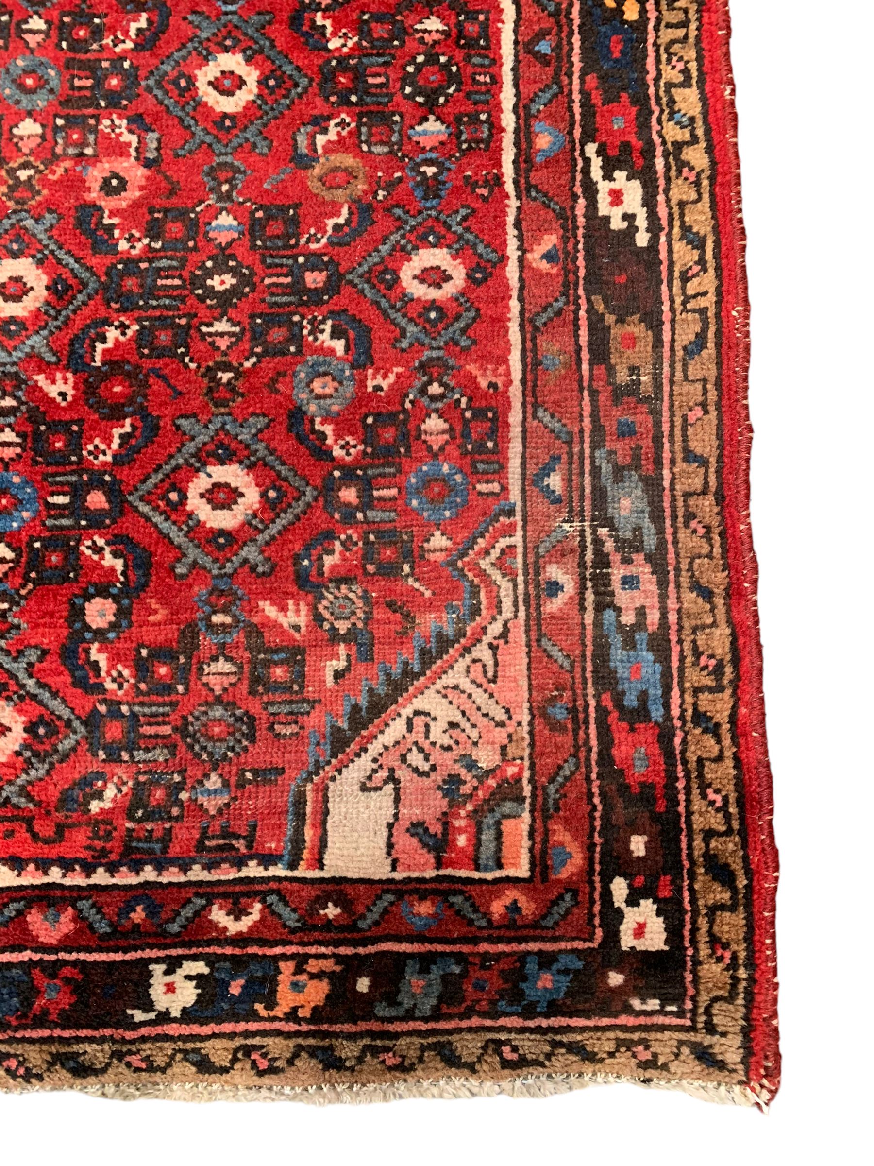 Persian crimson ground runner, the field decorated with Herati motifs,  three-band border, the main band decorated with repeating flowerheads 