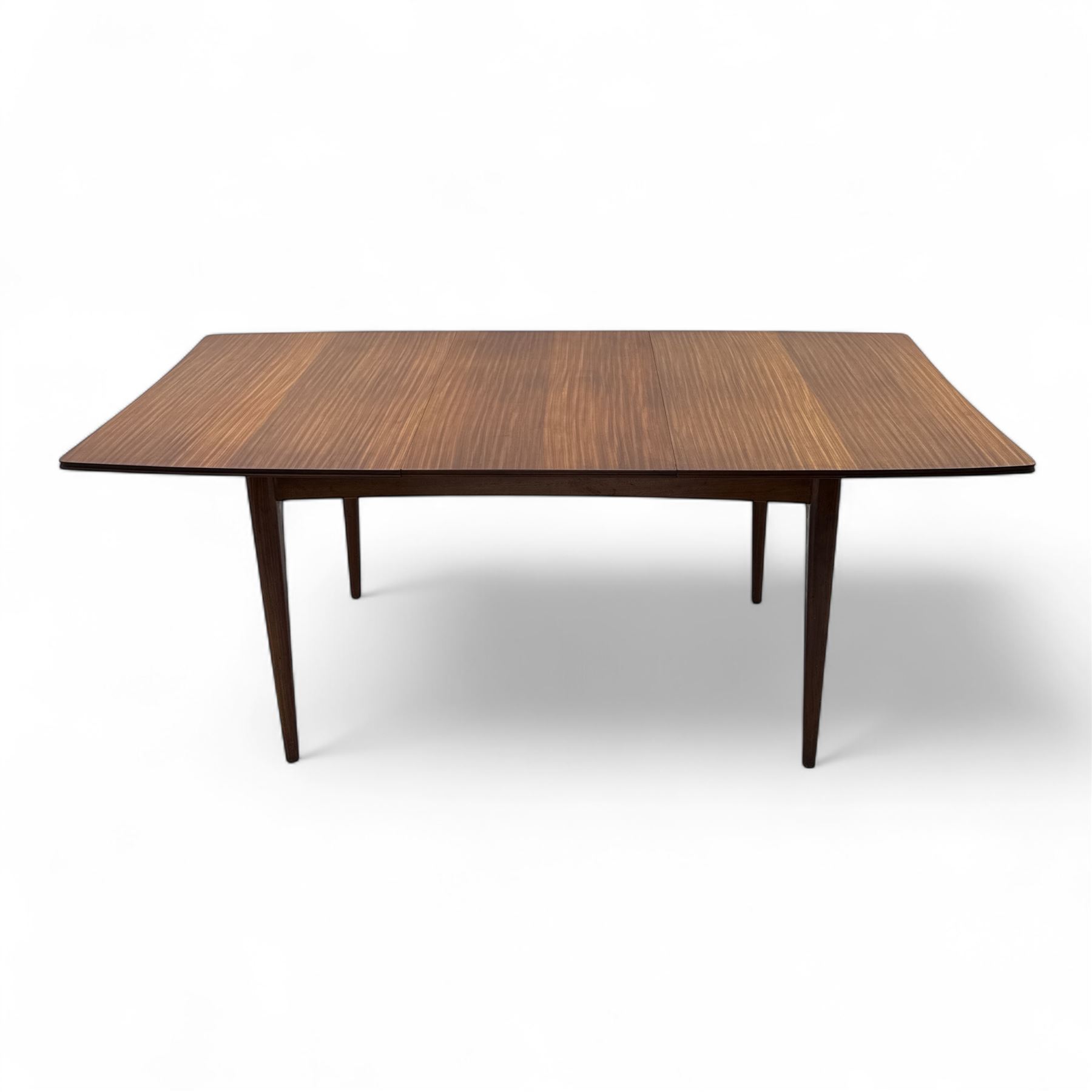 Richard Hornby for Fyne Ladye - mid-20th century afromosia teak dining table, tapered rectangular top with fluted edge and recess for spare leaf, raised on slender legs, teak framed chairs, of ladder back design, with drop-in seat, upholstered seat, with tapered front legs and slightly raked rear legs, retailed by Heals of London, table extended width 181cm depth 86cm height 74cm - chairs width 48cm depth 41cm height 87cm 