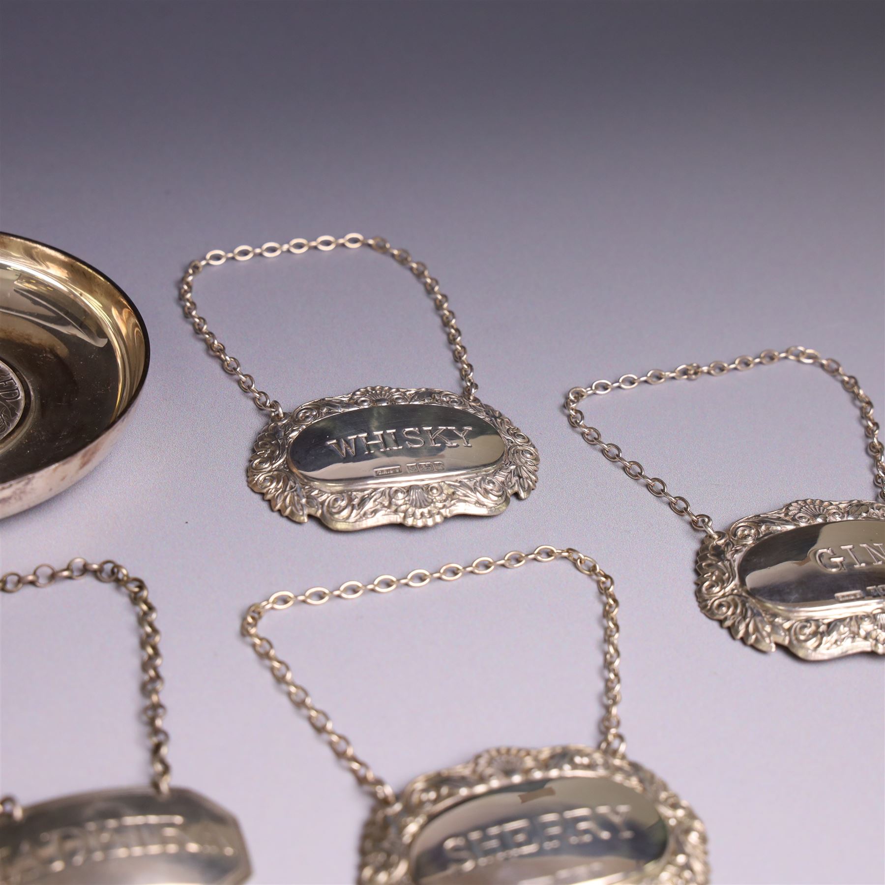 Group of silver, comprising silver mounted cigarette box, five decanter labels, page turner, commemorative teaspoon and a commemorative pin dish set with coin, all hallmarked