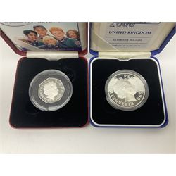 Queen Elizabeth II 2000 'The Queen Mother' silver proof five pound coin, 2000 'Millennium' silver proof five pounds, 2007 'Scouts' silver proof fifty pence, Tristan Da Cunha 2014 9ct gold 1 gram gold one crown coin, all cased with certificates and a 'Prince Charles 60th Birthday Commemorative Coin Cover' containing a 2008 silver proof five pound coin in folder (5)