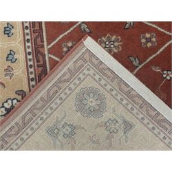 Late 20th century Royal Keshan 'Agra' hand-knotted wool rug, terracotta ground with central floral medallion and scrolling vines, enclosed by a cream border with repeating floral motifs