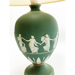 A Wedgwood green Jasperware table lamp, of ovoid form upon a spreading circular foot, decorated with dancing hours, with cream shade, overall H44.5cm. 