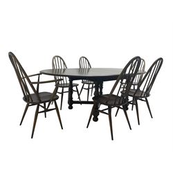 Ercol - 'Old Colonial' 705 elm extending dining table, oval top with hidden leaf, raised on turned supports united by X-stretcher (W163cm D108cm H72cm); and Ercol - set six  (4+2) dark elm 'Quaker Back Windsor Dining Chairs', hoop and stick backs 