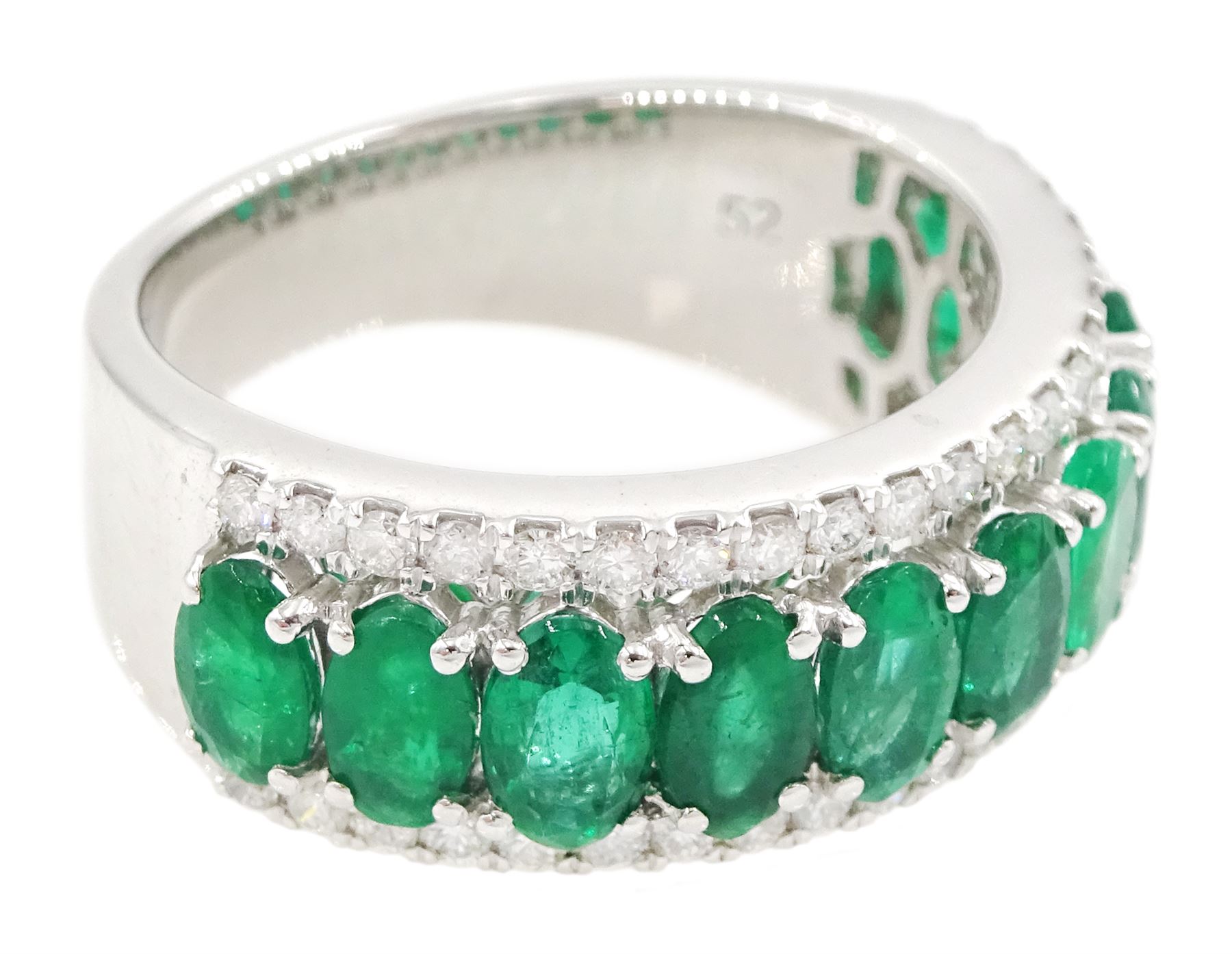 Platinum three row emerald and diamond half eternity ring, eleven oval cut emeralds with a row of round brilliant cut diamonds either side, hallmarked, total emerald weight approx 2.50 carat, total diamond weight approx 0.45 carat