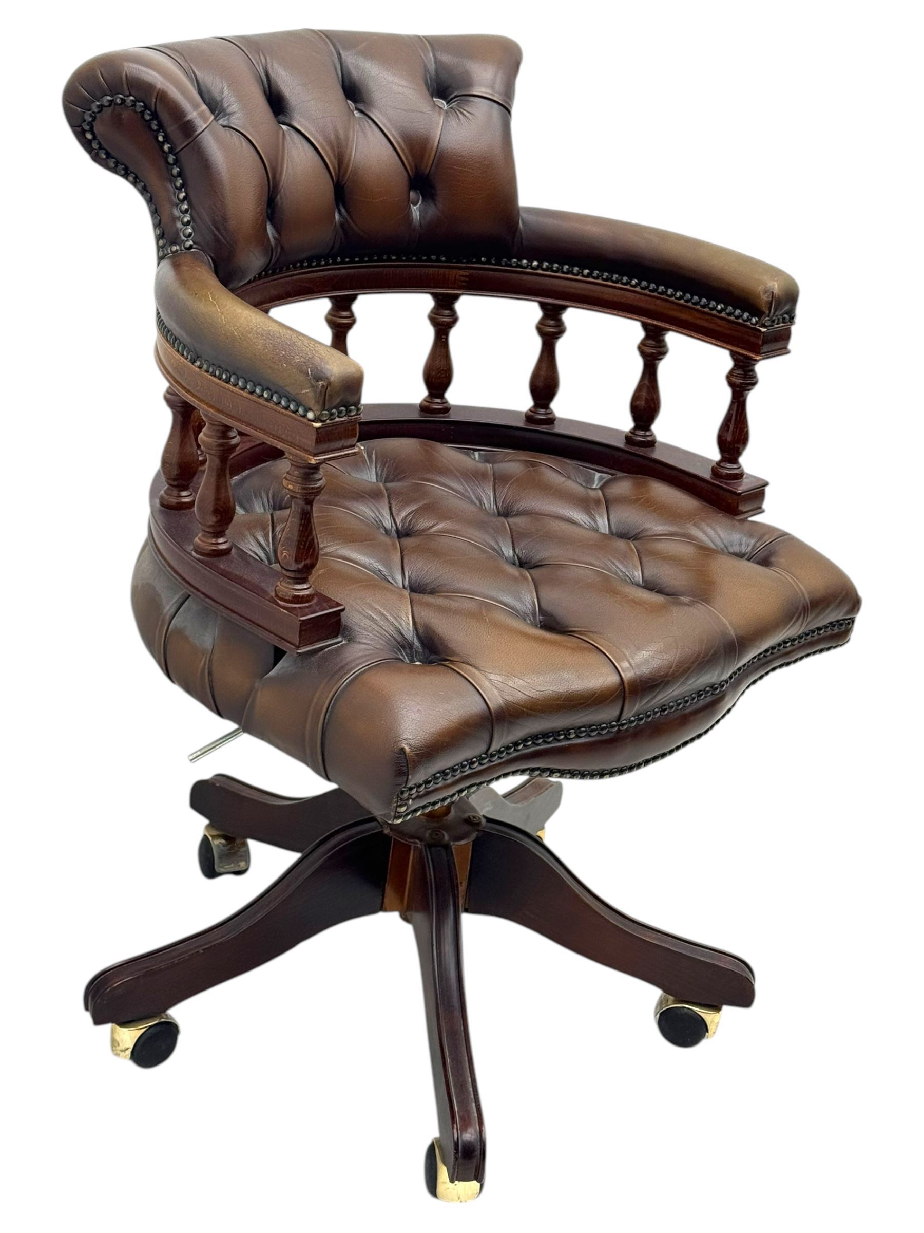 Mahogany framed swivel Captains desk chair, upholstered in brown buttoned leather, turned supports and swivel base on castors