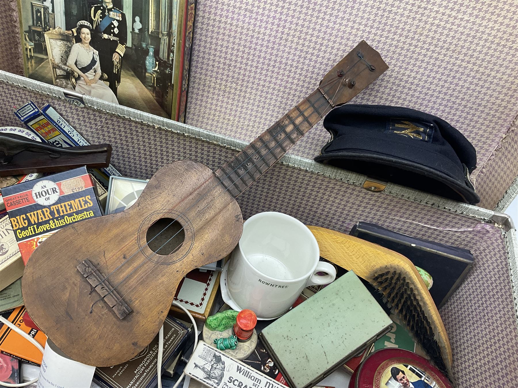 Ukelele, Westclox electric alarm  clock, vintage tins, National Rail hat, ceramics, boxed games, carved wood figures etc all housed in a suitcase