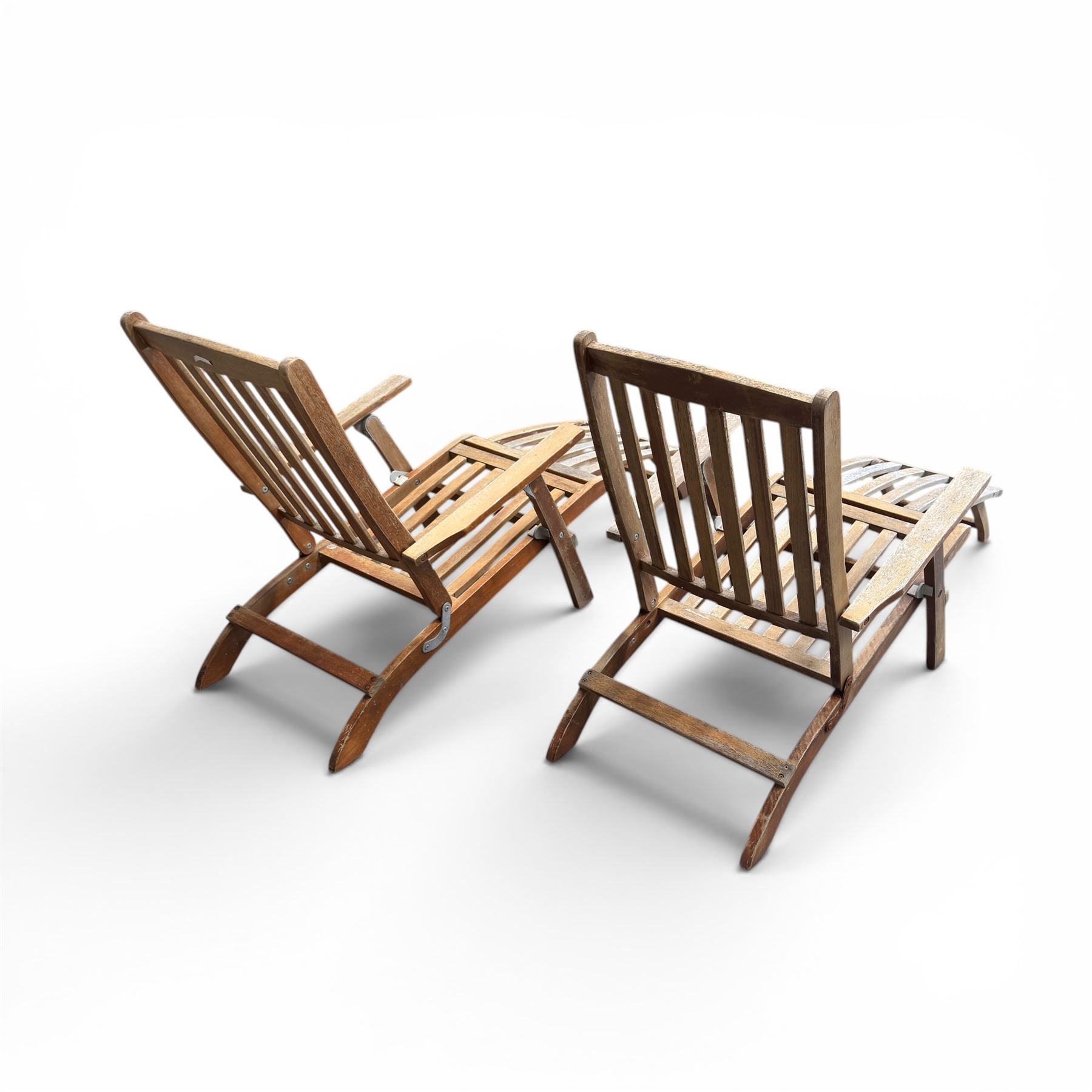 Pair of teak folding steamer chairs, with slatted backs, seats and extending footrests, adjustable recline.