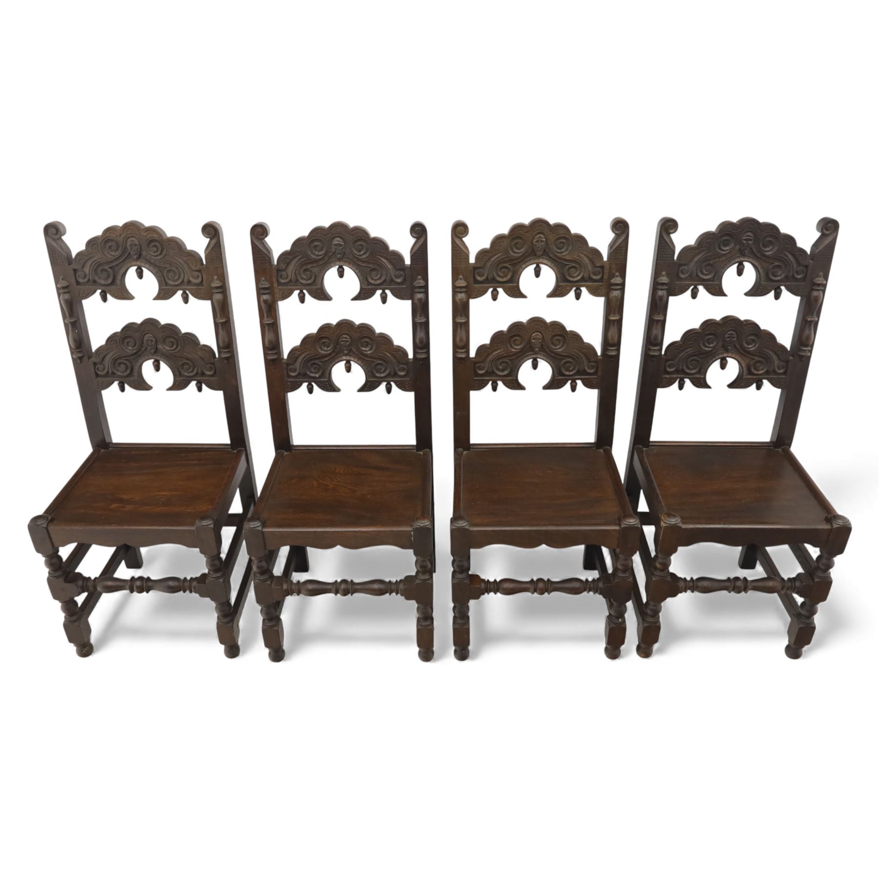 Early 20th century set of seven Jacobean Revival oak chairs, comprising pair of cavers and five chairs, each with carved mask and scroll decoration to the crest and and back rail, plain oak seat, upon turned front legs and block rear legs with conforming stretchers